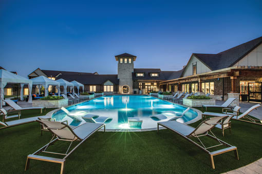 a large swimming pool with lounge chairs and umbrellas