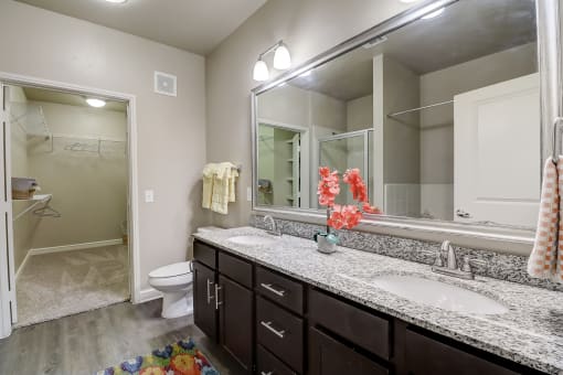 a bathroom with two sinks and a mirror and a toilet