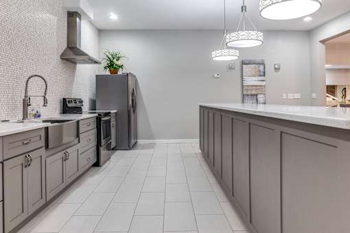 A modern kitchen with a grey color scheme and a large island.
