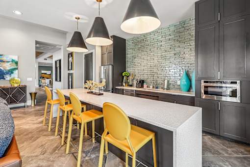 A kitchen with a white countertop and yellow chairs.