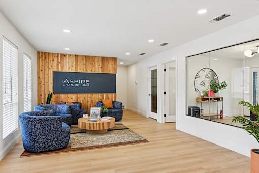 A living room with a blue chair and a sign that says "ASPIRE".
