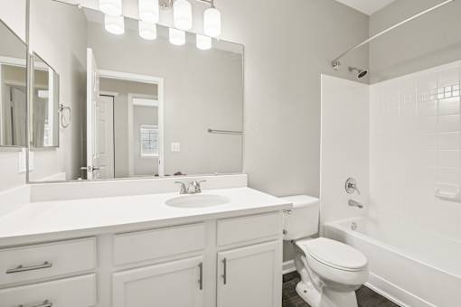A white bathroom with a sink, toilet, and bathtub.