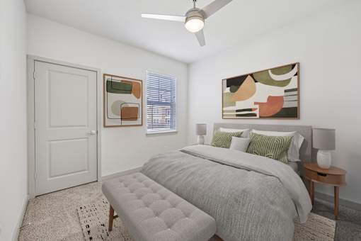 A bedroom with a bed, a bench, and a painting on the wall.