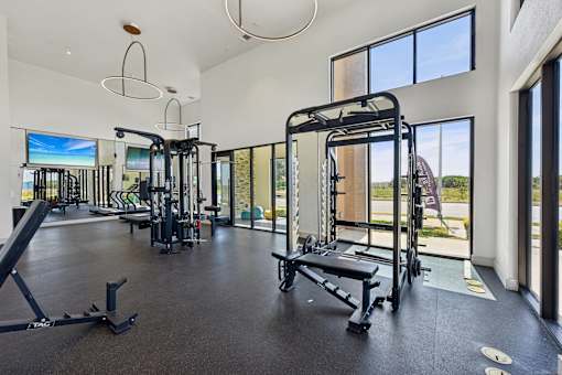 A spacious gym with a variety of equipment and a view of the outdoors.