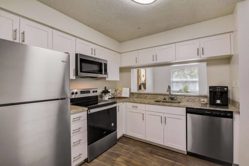 a kitchen with stainless steel appliances and white cabinets