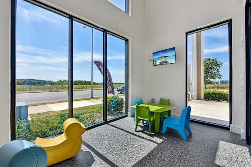 A room with a table and chairs and a television on the wall.
