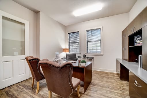 a room with a desk and two chairs