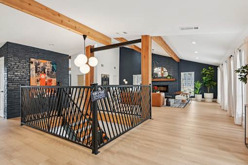 A black wrought iron gate leads to a room with a wooden floor.