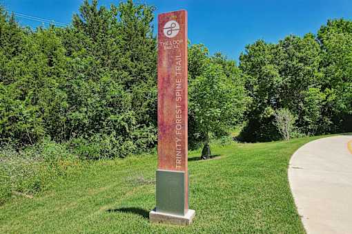 A signpost for the Honey Creek Trail stands in a grassy area.