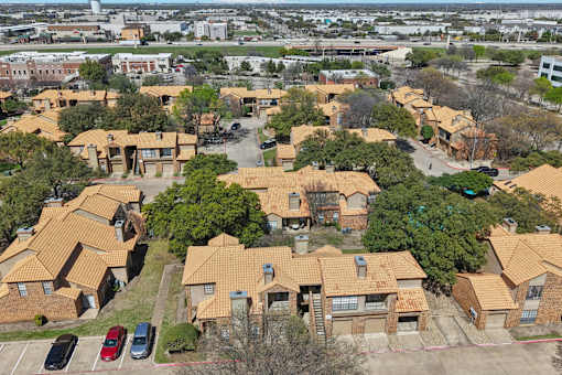 A bird's eye view of a residential area with houses and cars.