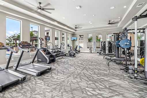 A spacious gym with treadmills, elliptical machines, and other exercise equipment.