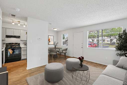 A modern living room with a grey ottoman and a grey couch.