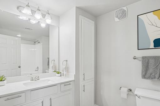 A bathroom with a white sink and a white toilet.