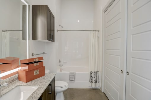 a white bathroom with a shower and a sink and a toilet