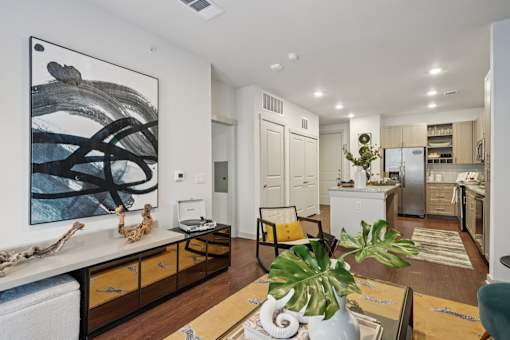 A modern kitchen with a large painting on the wall.