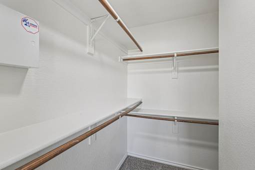 A white wall with a brown pipe and a white shelf.