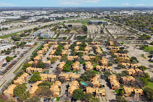 A suburban neighborhood with houses and a large building in the background.