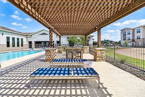 A wooden pergola over a blue and white checkered table.