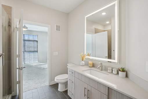 A modern bathroom with a sleek backlit mirror.