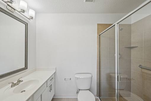 A bathroom with a toilet, sink, and shower.