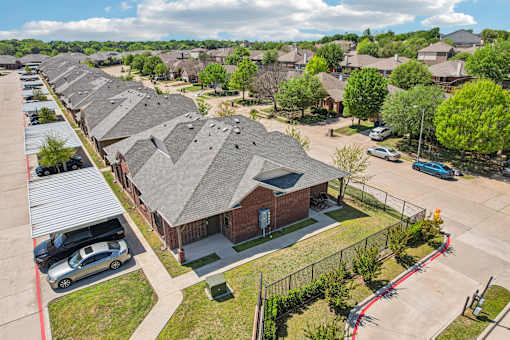 A row of houses with a car parked in front of each.