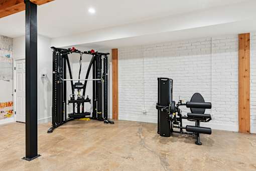 A black home gym setup with a squat rack and a leg press machine.