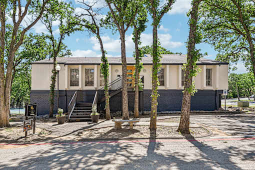 A building with a grey facade surrounded by trees.