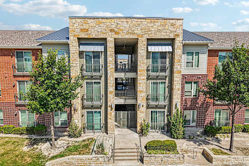 A large stone building with a metal roof and a balcony.