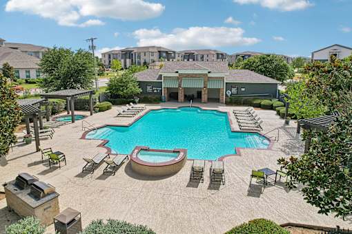 A large swimming pool surrounded by lounge chairs and umbrellas.