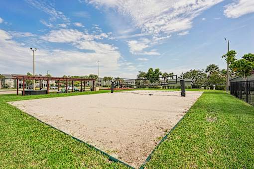 A sandy area in a park with a green border.