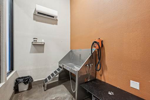 A room with orange walls has a table, a bench, and a window.