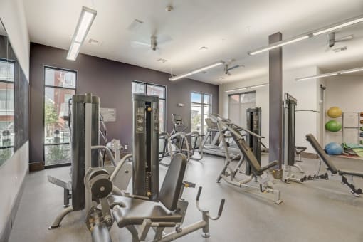 a gym with weights and cardio equipment at the district flats apartments