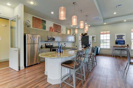 A kitchen with a center island and a refrigerator.