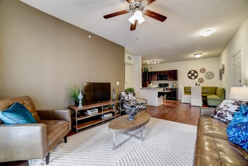 a living room with a ceiling fan and hardwood flooring
