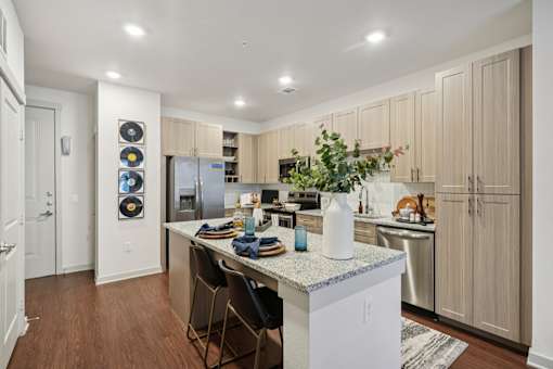 A kitchen with a white island and wooden cabinets.