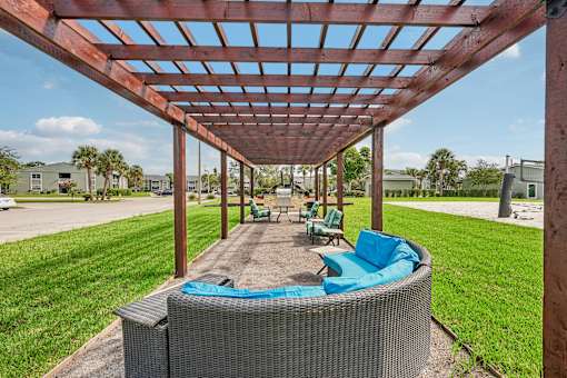 A patio with a hot tub and a pergola.
