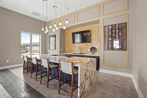 A modern kitchen with a bar area and a television mounted on the wall.
