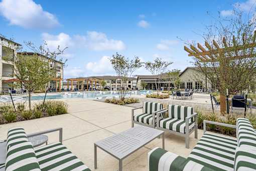 A sunny day at the poolside with green and white striped sun loungers.