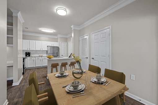 a dining room and kitchen with a wooden table and chairs