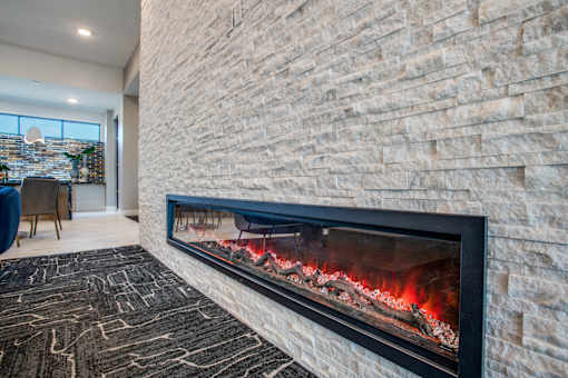 Modern linear fireplace set into a textured stone feature wall.