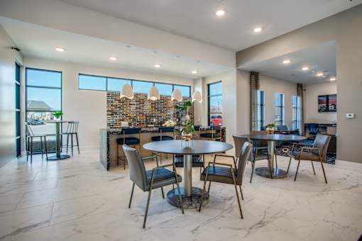 Community dining area with café tables, chairs, and adjacent serving counter.