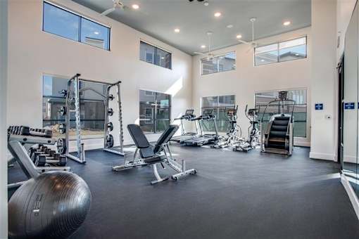 Spacious fitness center with treadmills, strength equipment, and soaring ceilings.