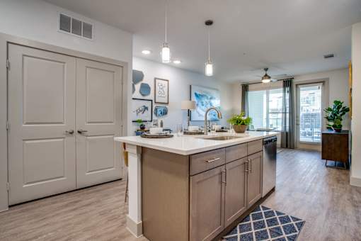 Kitchen island with sink and dishwasher looking toward living room and patio door.