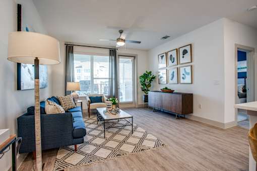 Spacious living room with patterned rug, media console, and plenty of natural light.