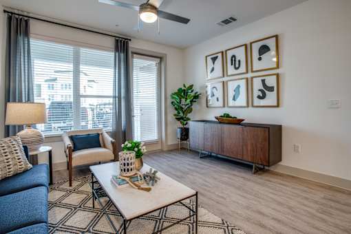 Stylish living area with blue couch, coffee table décor, and framed artwork wall.