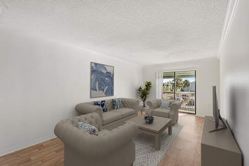 A living room with a couch, a coffee table, and a painting on the wall.