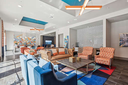 A living room with a glass table and blue chairs.
