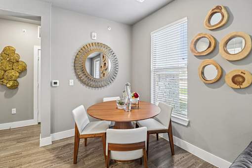 A dining room with a round table and chairs.