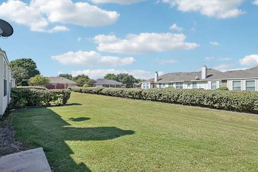 A grassy area with a building in the background.