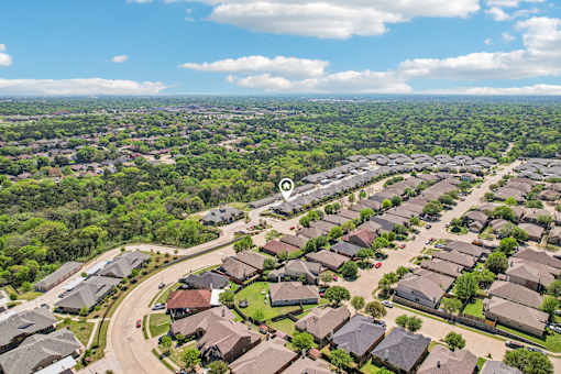 A bird's eye view of a residential area with houses and a road.
